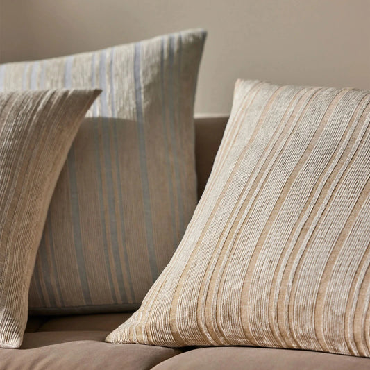 3 Adriana cushions in a lined chenille pattern on a beige sofa