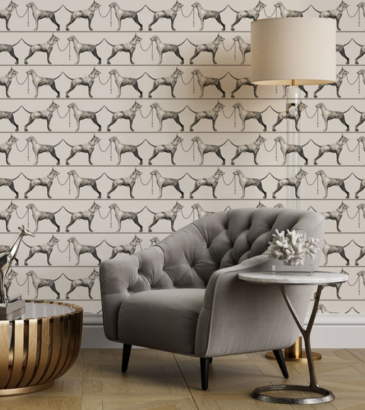Gray armchair in a room with patterned wallpaper featuring dog illustrations.