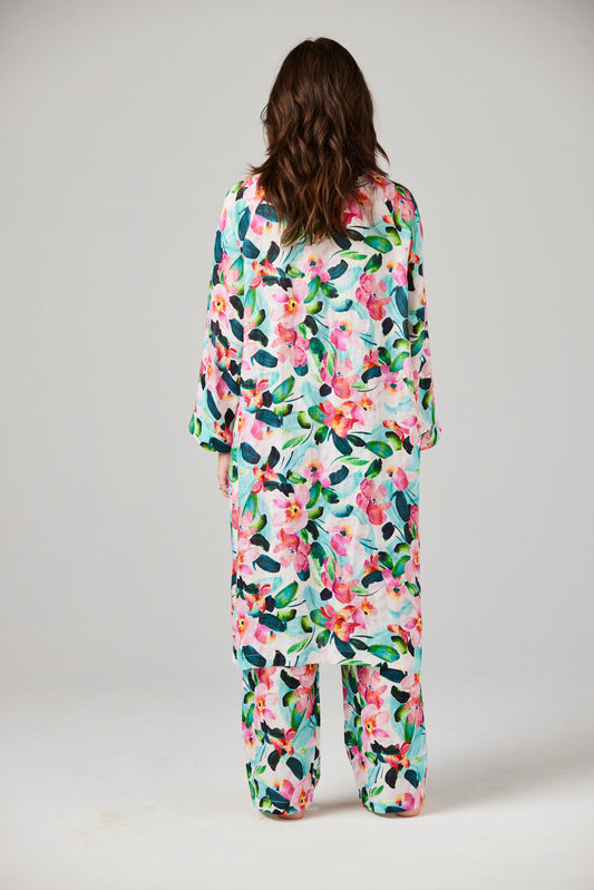 Person wearing a floral linen robe against a plain background
