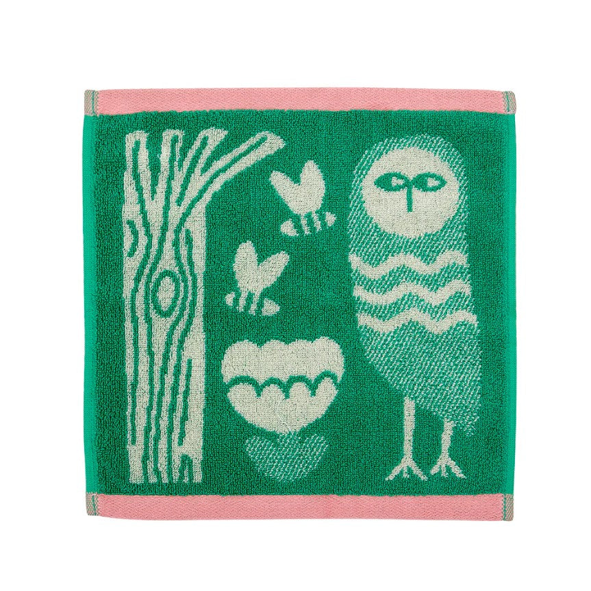 Green towel with owl and nature-themed design on a white background