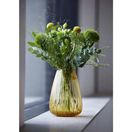 Glass vase with greenery on a windowsill