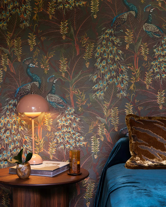 Room interior with peacock-themed wallpaper, lamp, and decorative items.