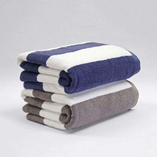 Stack of folded towels in blue, white, and gray on a light gray background
