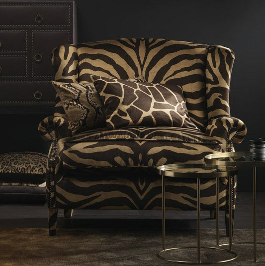Camouflage fabric Zebra-patterned armchair in a dark room with a side table.