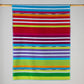 Multi striped towel in vibrant colours, blue, pink, neon yellow, green, purple