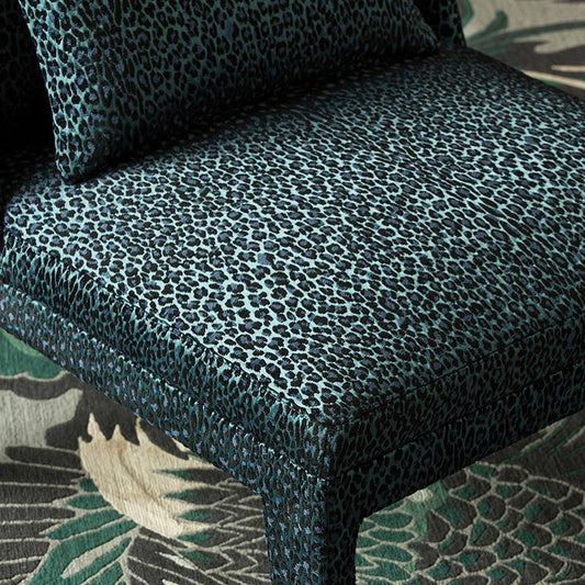 Patterned fabric on a piece of furniture with a floral rug in the background