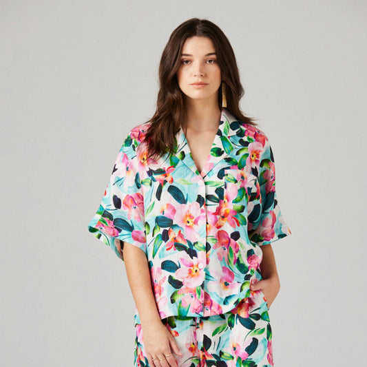 Woman wearing a floral pajama set on a plain background
