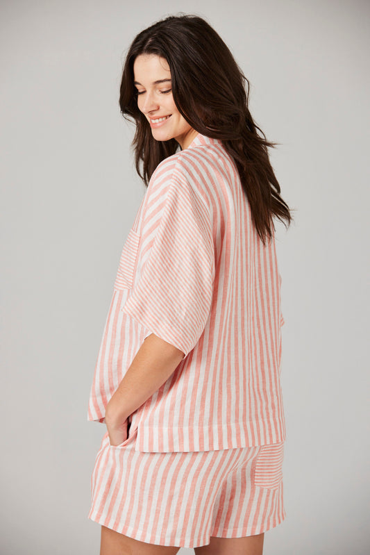 Woman wearing a pink and white striped outfit on a plain background