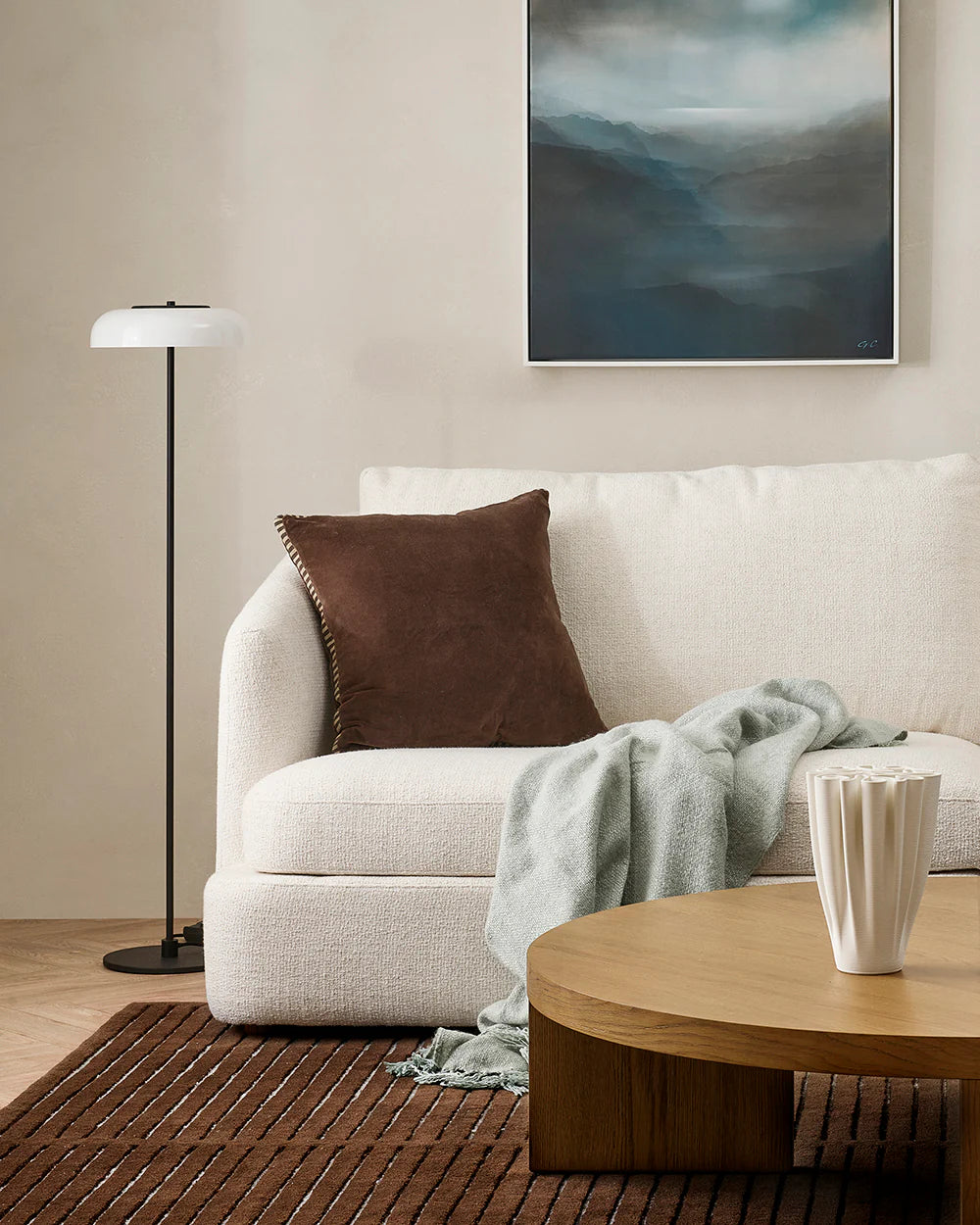 Living room with a beige sofa, brown pillow, and wooden coffee table.