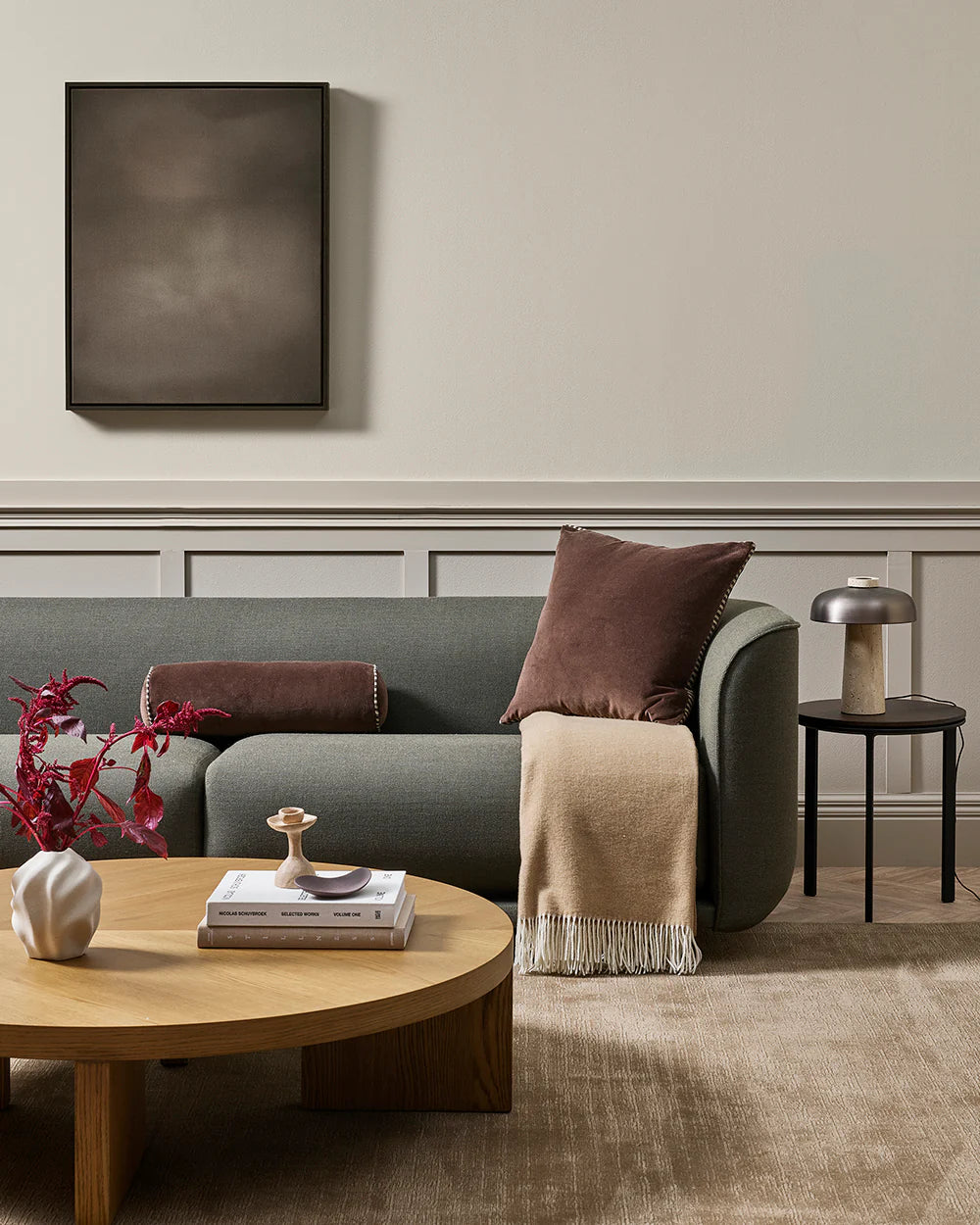 Modern living room with a gray sofa, wooden coffee table, and decorative items.