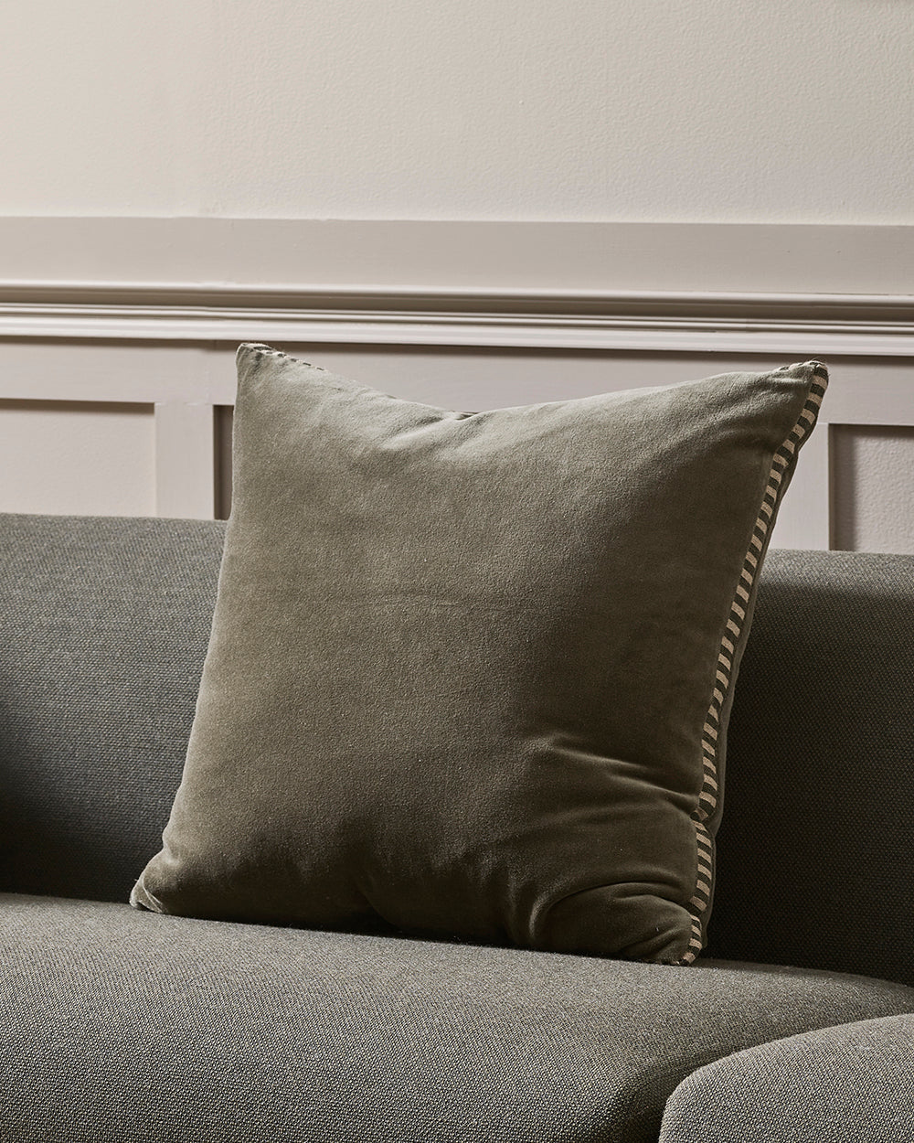 Thyme cushion on a gray sofa against a neutral wall