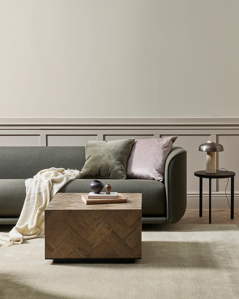 Modern living room with a gray sofa, wooden coffee table, and side table.