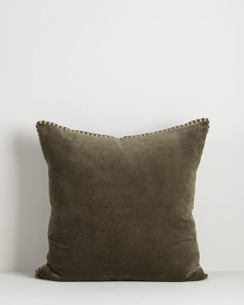 Olive pillow with decorative edge on a white background