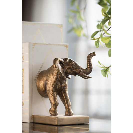 Bronze elephant statue on a reflective surface with a blurred background
