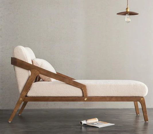 Modern lounge chaise with wooden frame and beige cushion against a plain wall.
