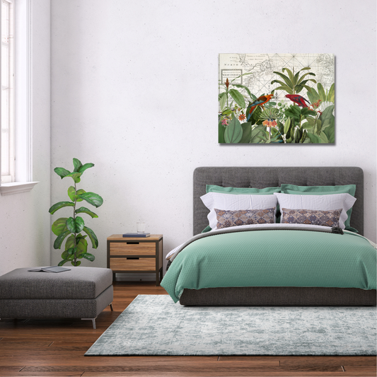 tropical bird canvas in a vintage style above a grey and green bed. Green foliage in the corner of a white room with a window and a grey ottoman underneath the window. The bed is seated on a grey and white marle rug