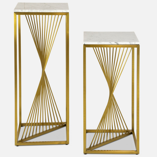 two Giro pedestals side by side with a marble top and gold, twisted spokes in a gold box frame