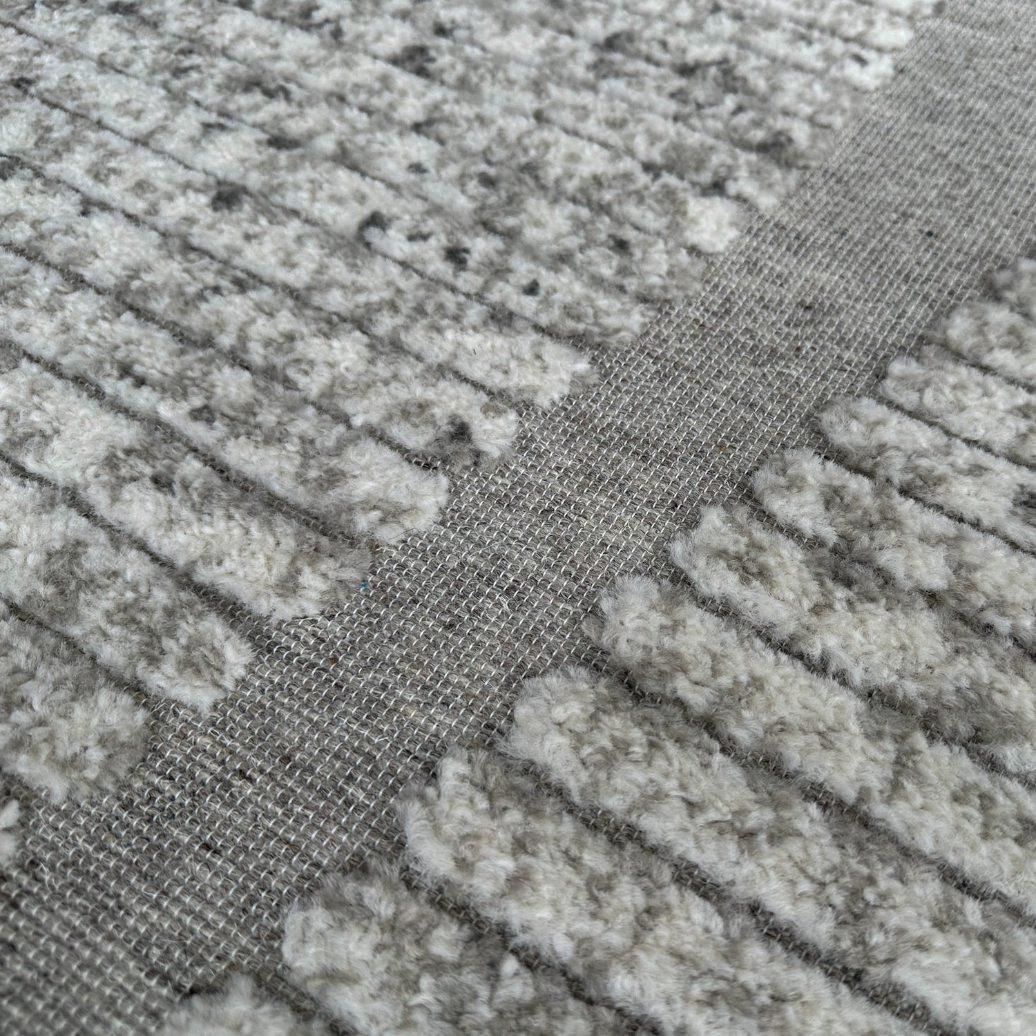Close-up of textured gray carpet with a focus on the pattern and material.