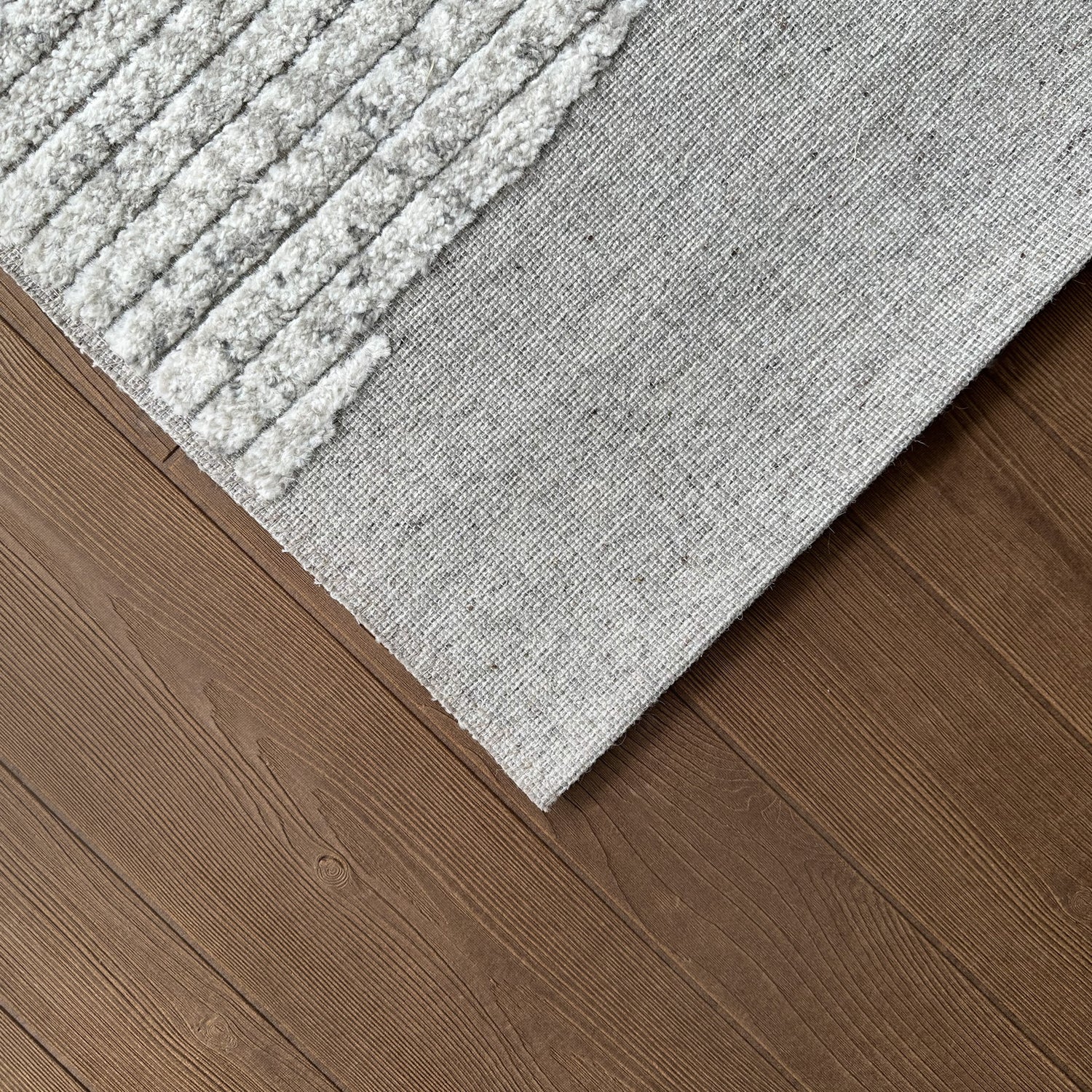 Gray textured rug on a wooden floor