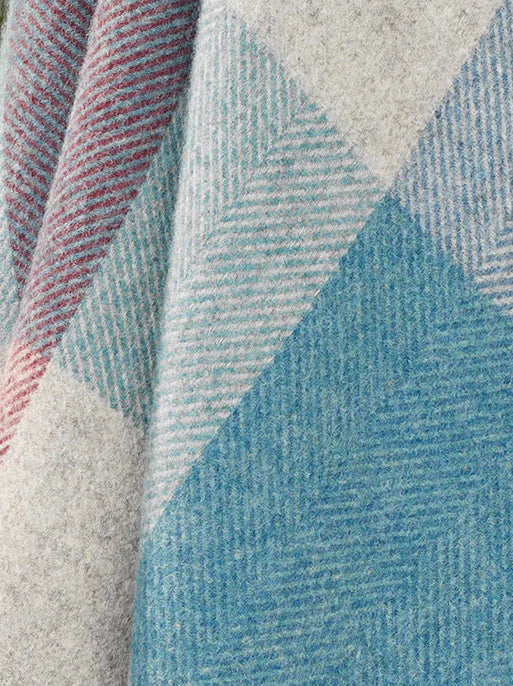 Close-up of a textured fabric with geometric pattern in blue, gray, and red.