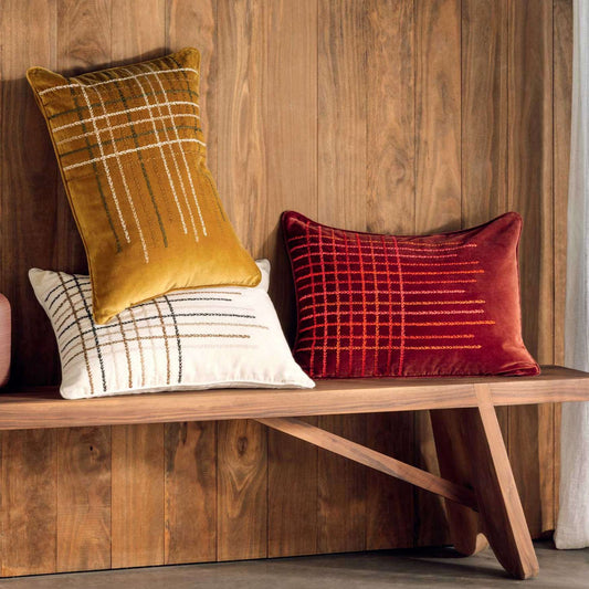 3 cushions with embroidered lines in white, red and yellow