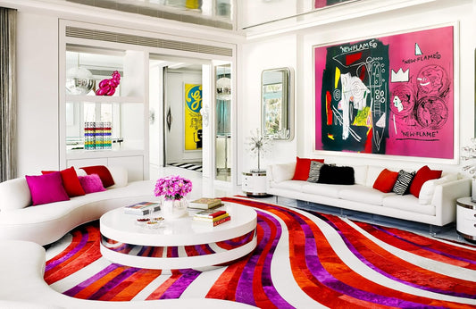 Modern living room with colorful rug, white sofa, and abstract art.