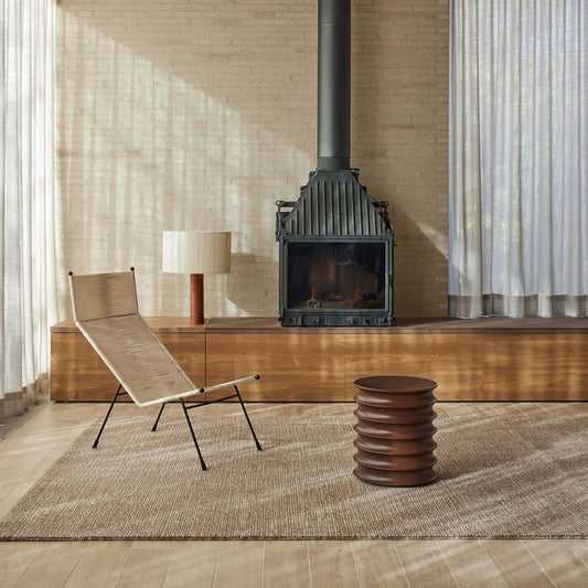 Modern living room with a fireplace, lounge chair, and table.