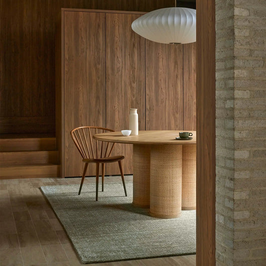 Modern dining room with wooden table and chairs, neutral color palette.