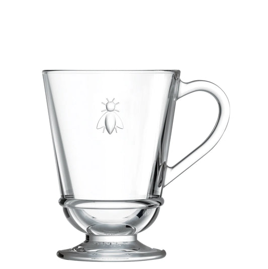 Clear glass mug with handle and bee emblem on a white background