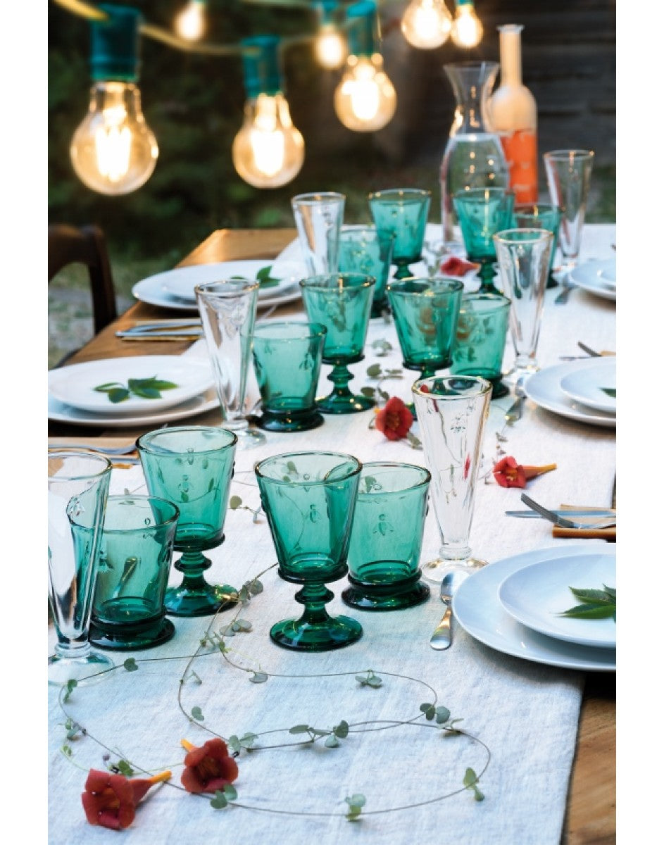 Table setting with turquoise glasses and white tablecloth outdoors
