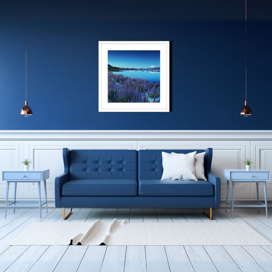 Modern living room with a blue sofa, white walls, and a framed picture of a mountain landscape.
