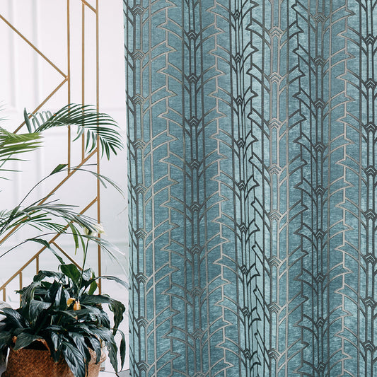 Patterned blue curtain with geometric design next to a plant