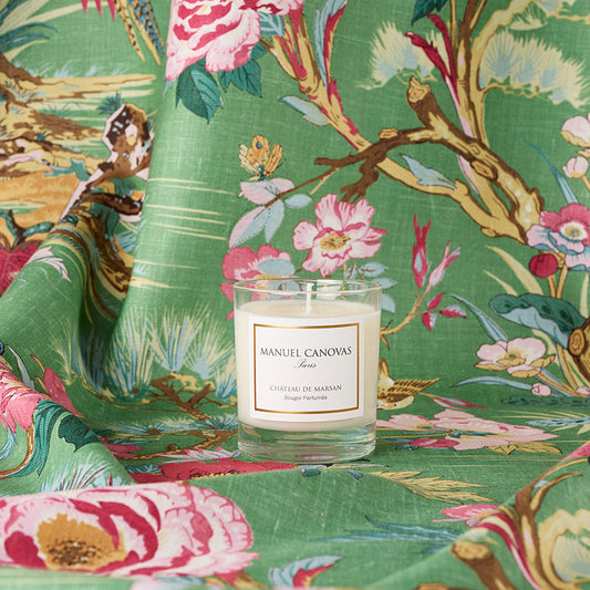 Candle with 'Manuel Canovas' label on a floral fabric background