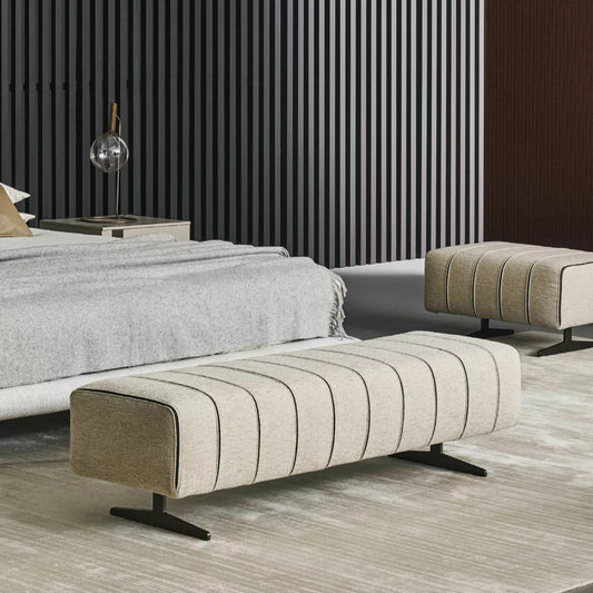 Modern living room with a striped wall, sofa, and ottoman.