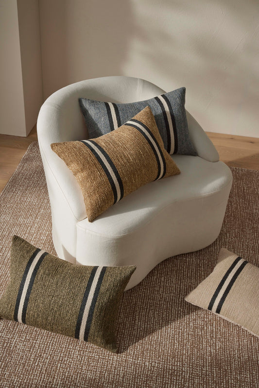 White armchair with patterned cushions on a textured rug