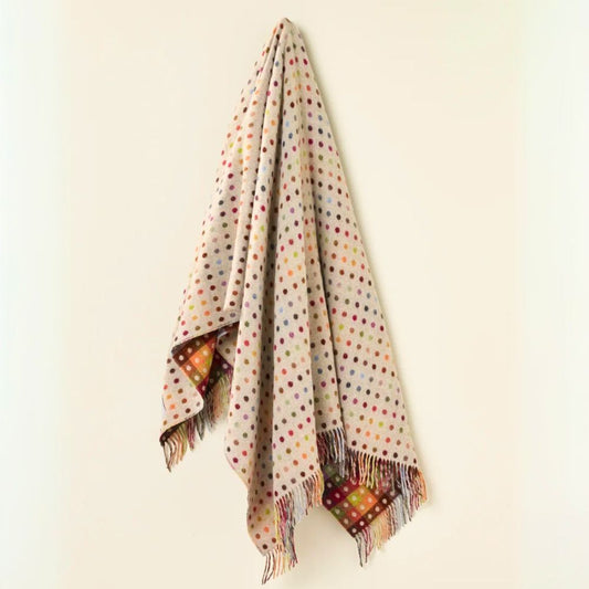 Polka dot throw with fringes on a beige background