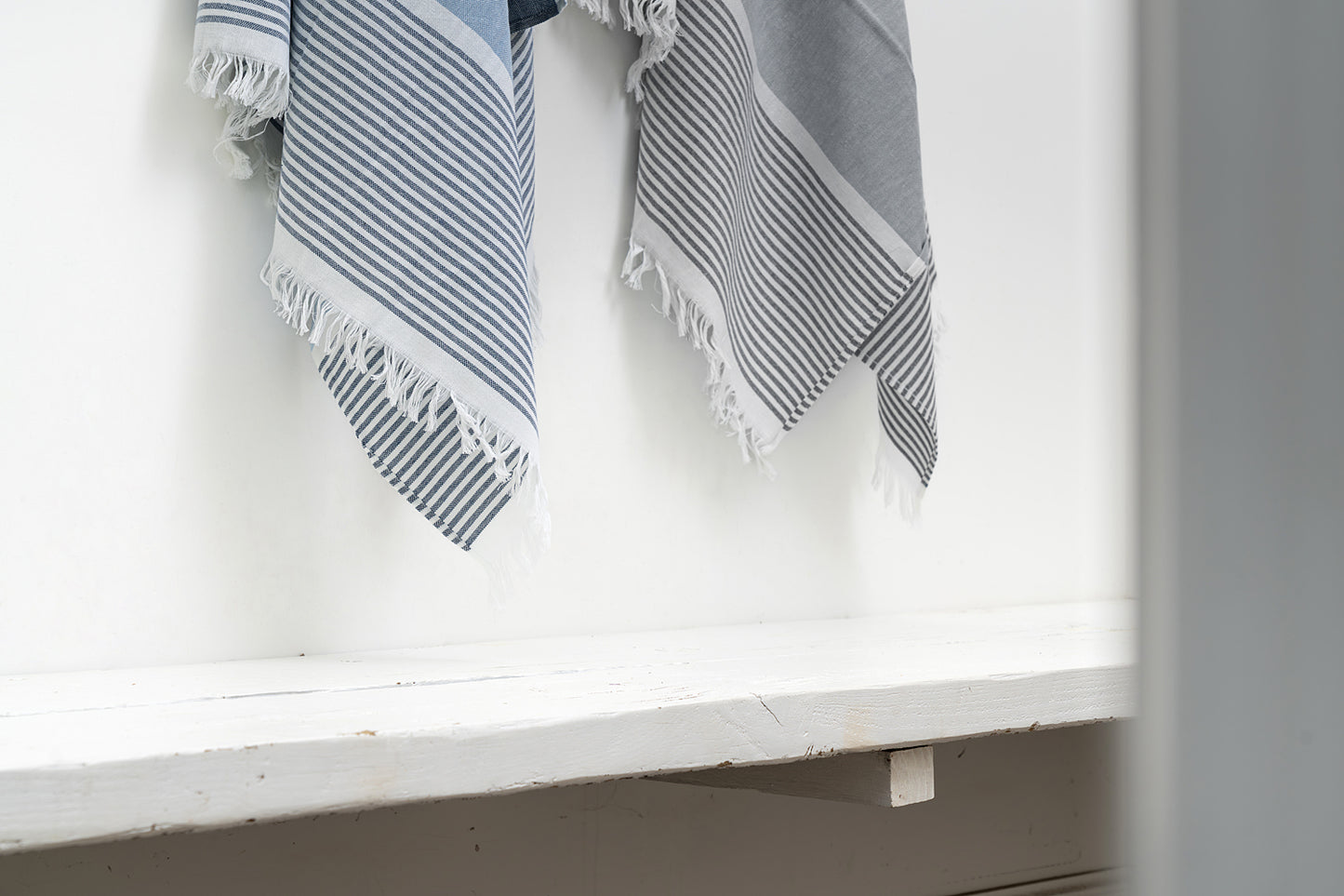 Striped towel hanging on a white shelf