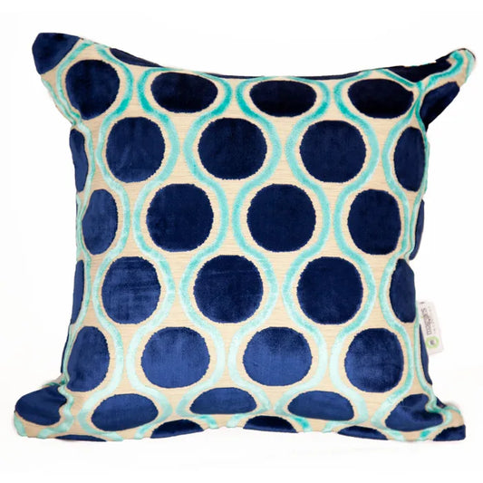 Decorative pillow with blue and green polka dot pattern on a white background
