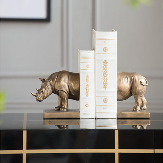 Decorative bookends shaped like rhinos on a shelf with a neutral background