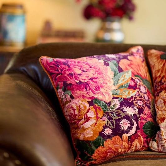 Becky Lee cushion in a large floral print of rose peonies and colours of aubergine, orange, green and pink