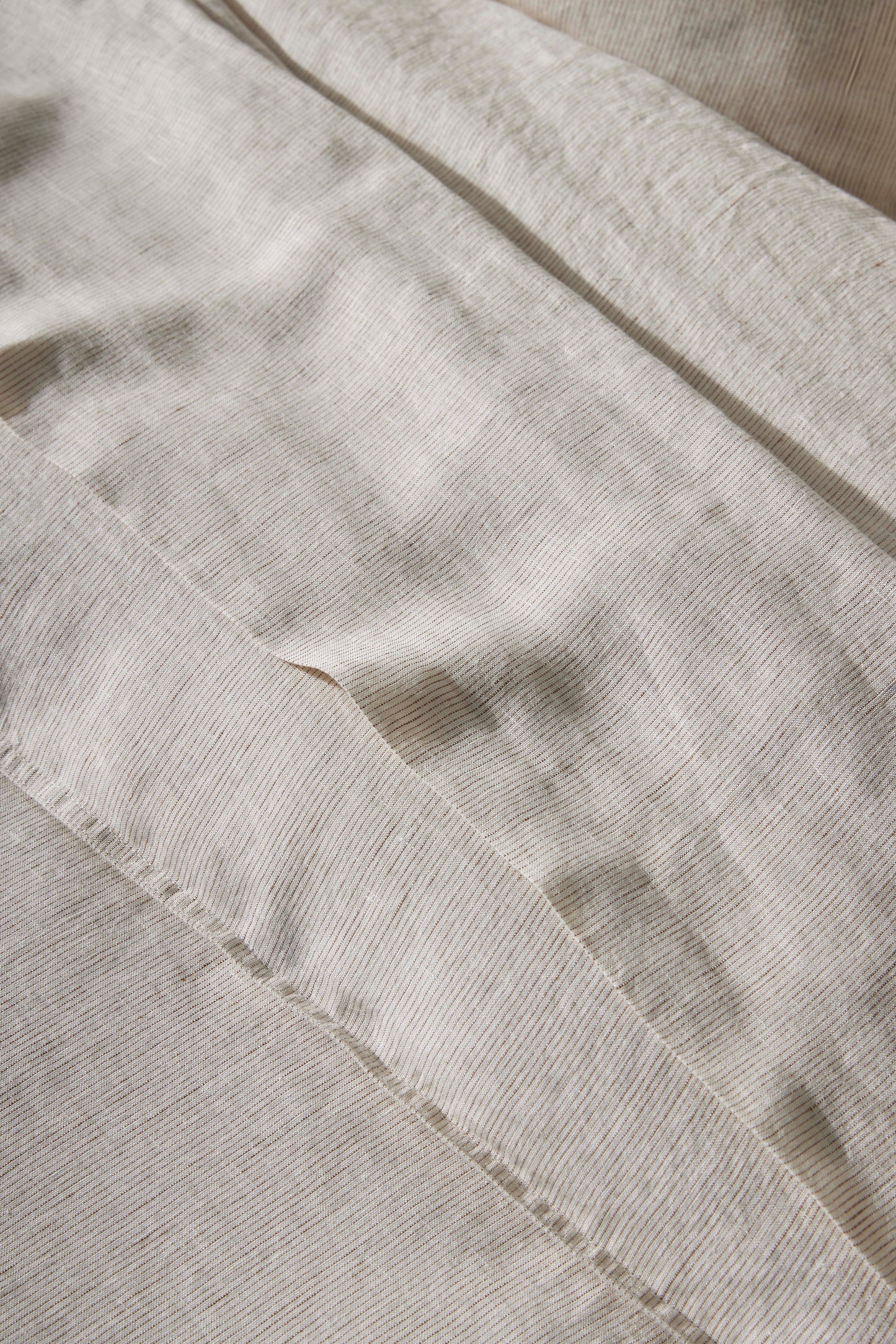 Close-up of beige Sova bed linen with a subtle pattern