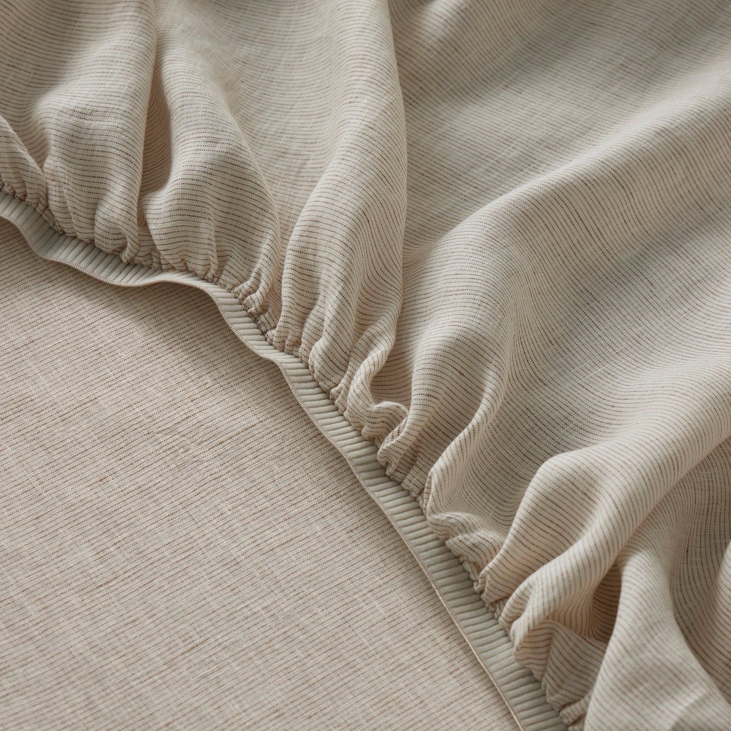 Close-up of Sova linen fitted sheet on a bed