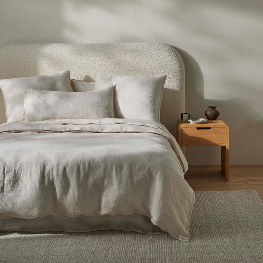 Neatly made bed with Sova bed linen in a minimalistic bedroom setting.