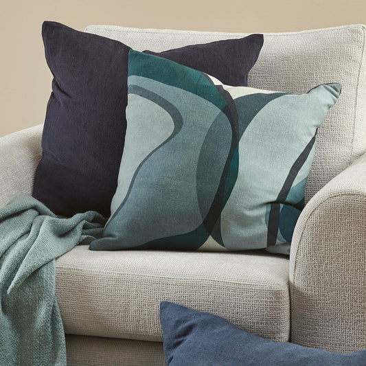 Gray sofa with decorative pillows featuring wavy patterns in shades of blue and gray.