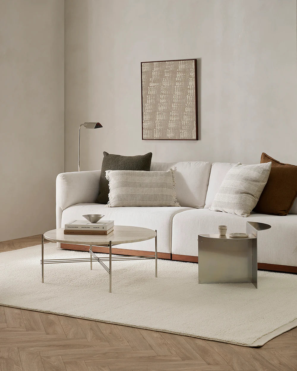 Modern living room with a white sofa, coffee table, and decorative pillows.