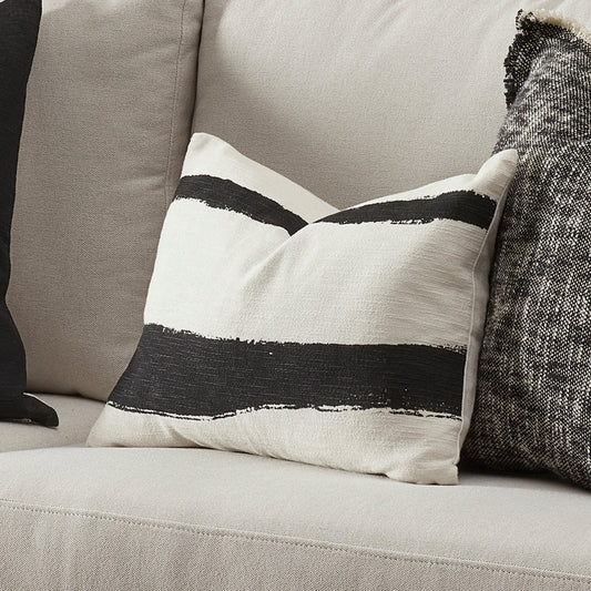 Decorative pillow with black and white stripes on a gray sofa