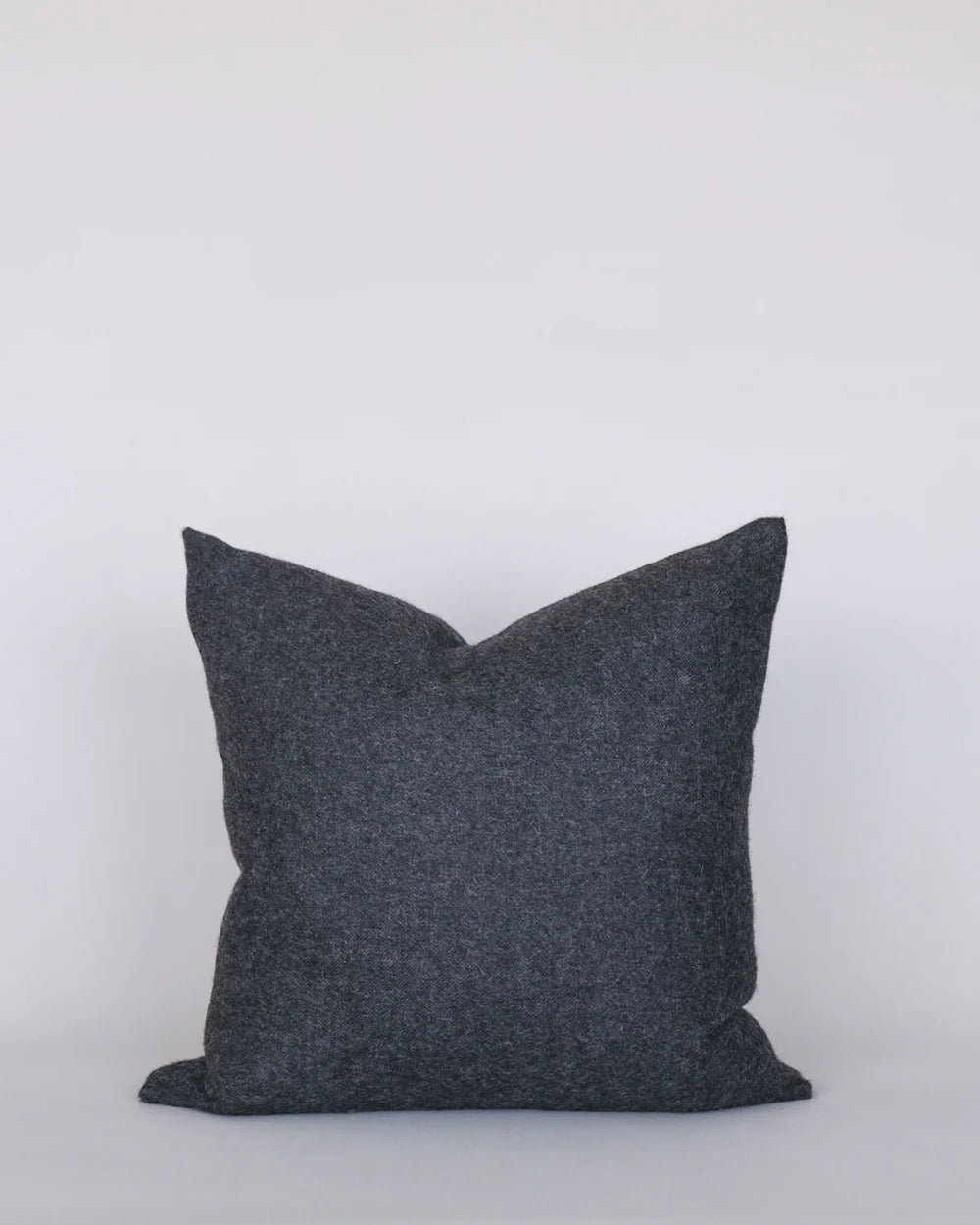 Dark gray pillow on a light gray background