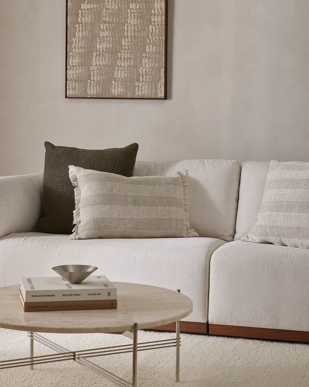 White sectional sofa with decorative pillows in a living room setting.