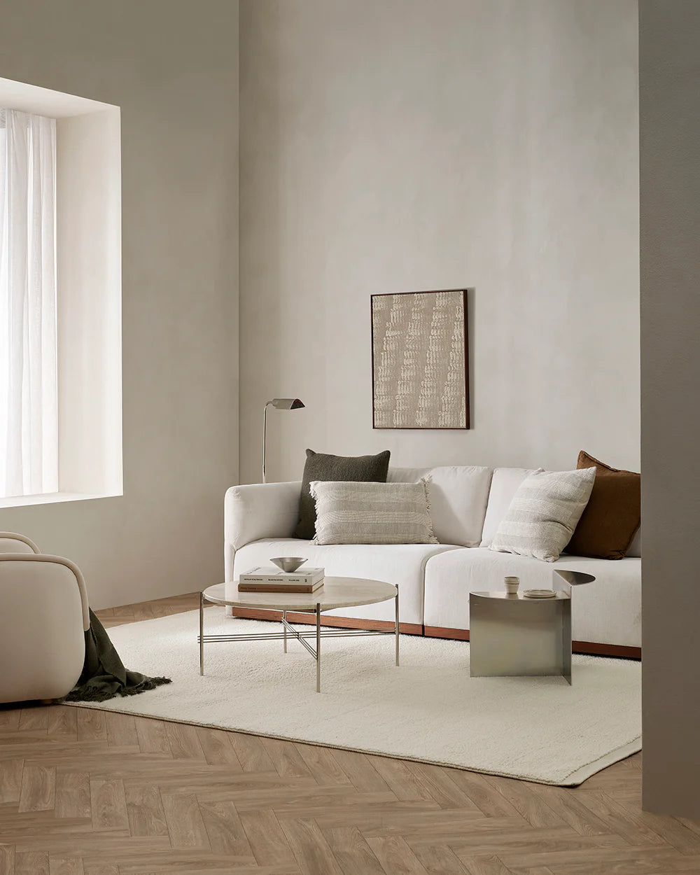 Modern living room with a white sofa, coffee table, and decorative pillows.