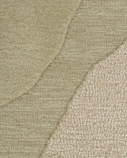 Close-up of a textured area rug with a modern abstract design, featuring three distinct woven patterns in shades of beige and light green.